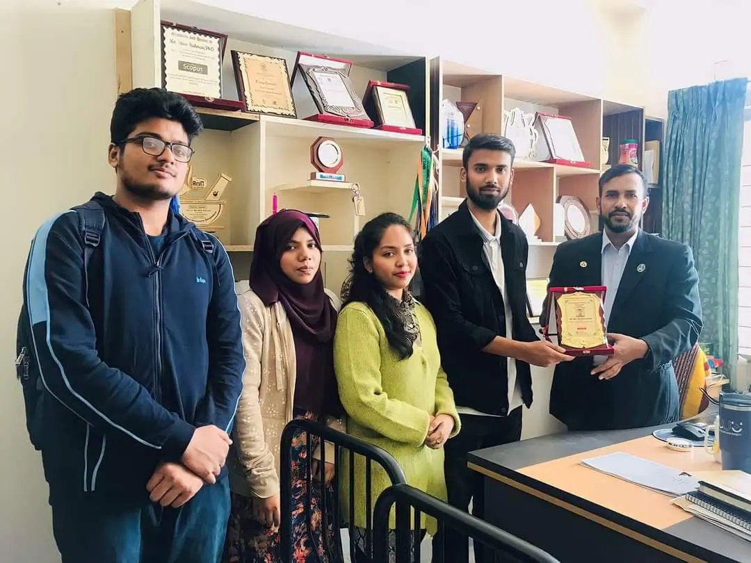 The BioPC team presenting a commemorative crest to a faculty member after a partner university session